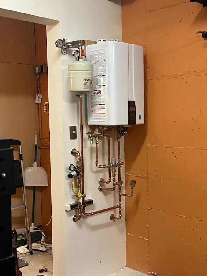 Plumbing technician inspecting water heater connections in Mauldin